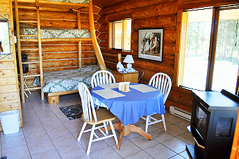 Dining area with cozy stove heater and beds.